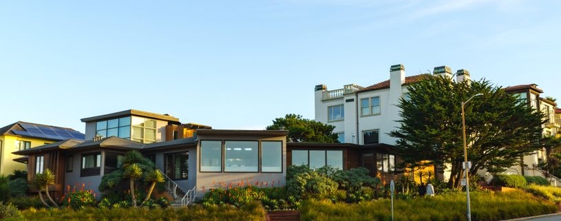 Bright, sunny street in a residential Atlanta neighborhood, featuring a mix of beautiful modern and traditional homes, rep...