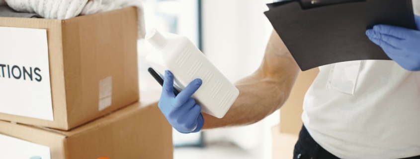 Diverse group of volunteers works together in a brightly lit space, sorting through boxes of food, water, and clothing don...