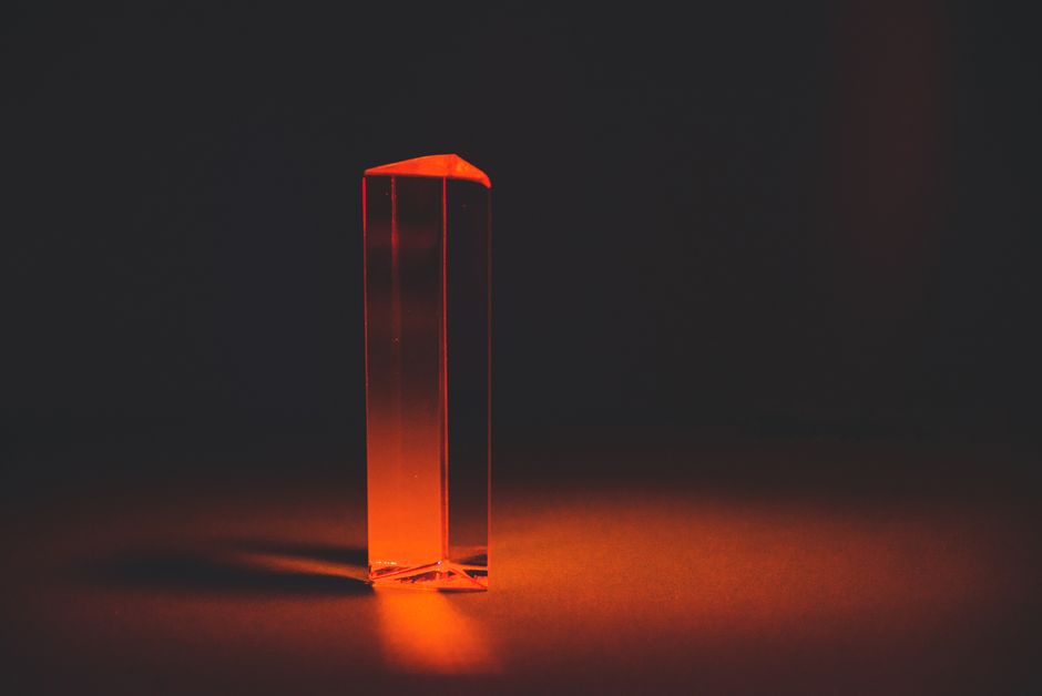 A single, focused beam of white light enters a glass prism and emerges as a clear ray, symbolizing how AI synthesizes complex information into a simple answer.